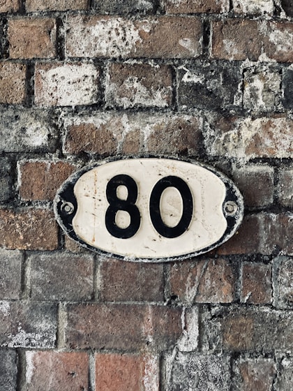 a brick wall with a black and white sign on it