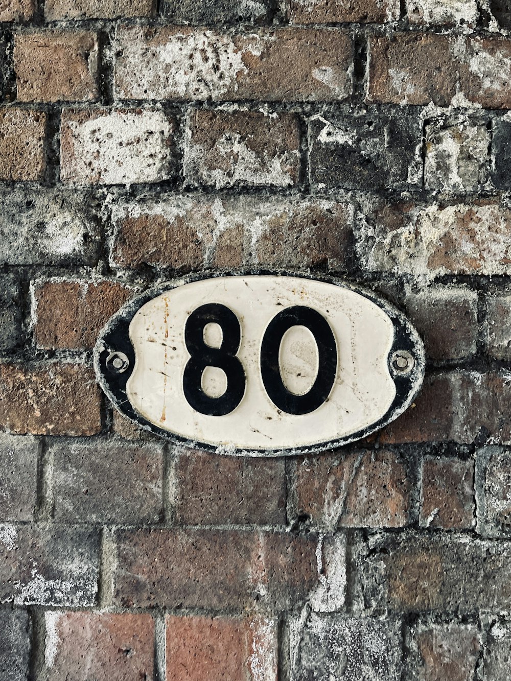 a brick wall with a black and white sign on it
