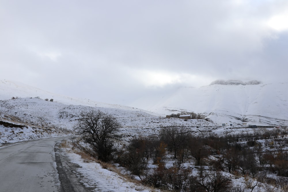 a snow covered mountain with a road in the foreground