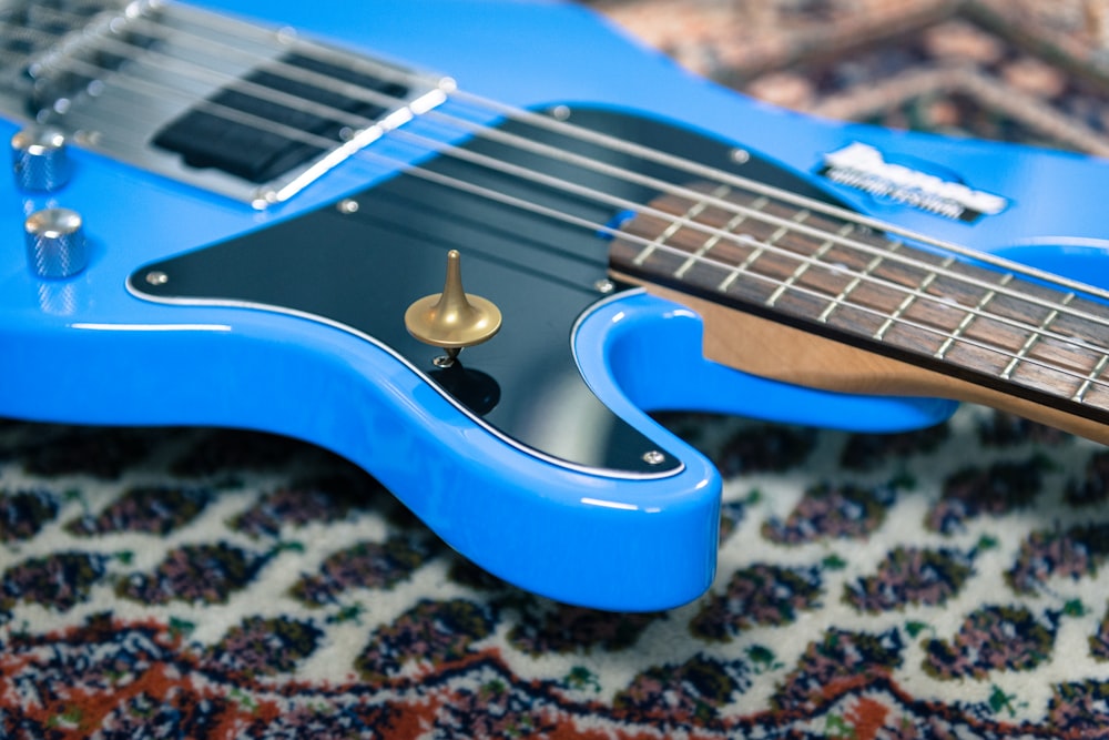 a blue guitar sitting on top of a rug