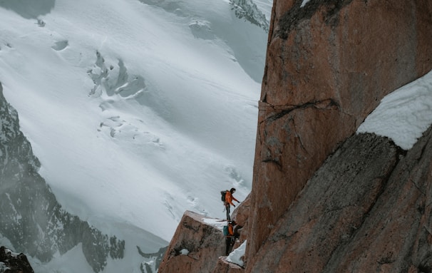 a man standing on the side of a snow covered mountain