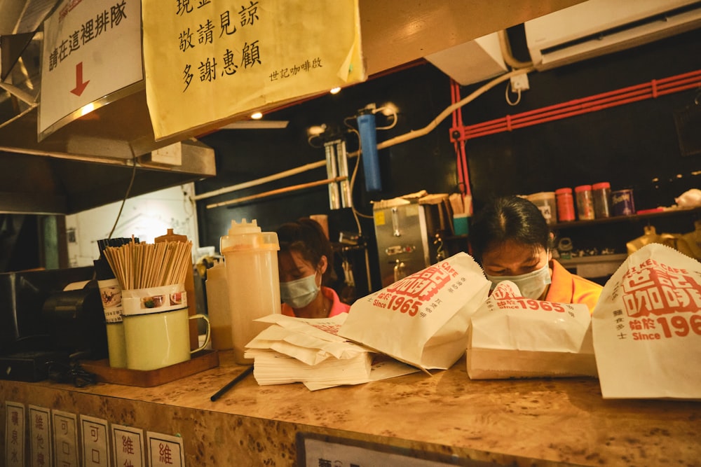 a woman sitting at a counter in a fast food restaurant