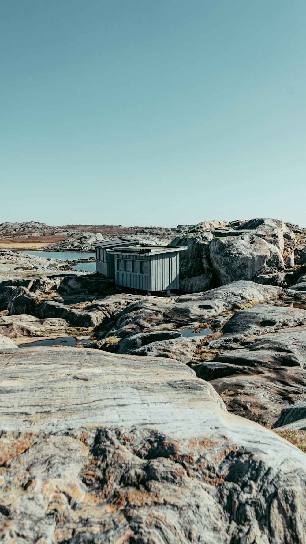 a small building sitting on top of a rocky beach