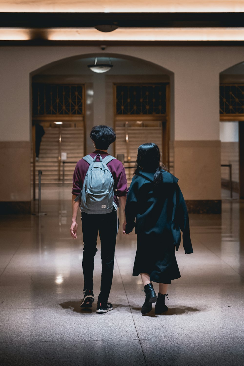 a couple of people that are walking down a hall