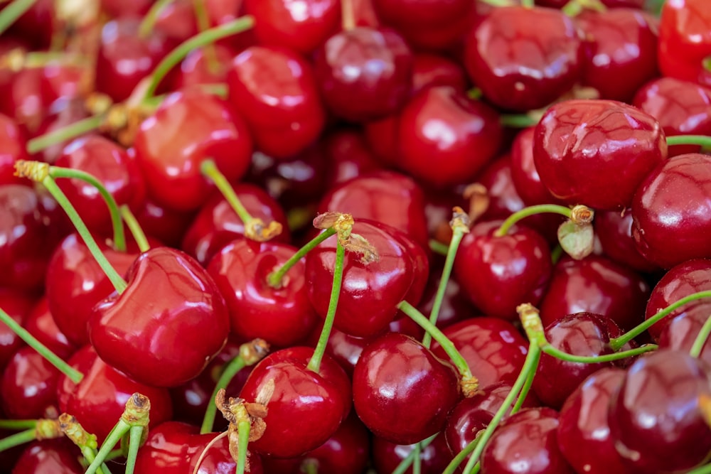 a pile of red cherries sitting on top of each other