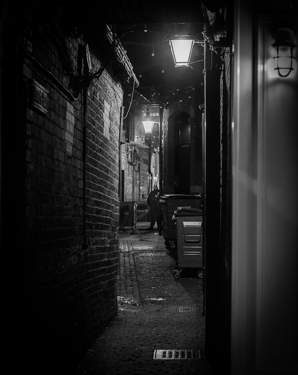 a black and white photo of a dark alley