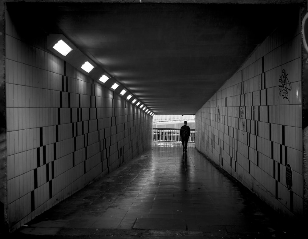 a man is walking down a long hallway