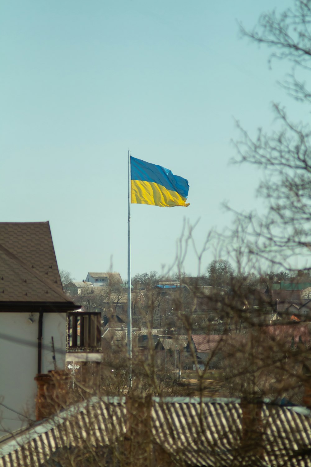 a blue and yellow flag flying on top of a building