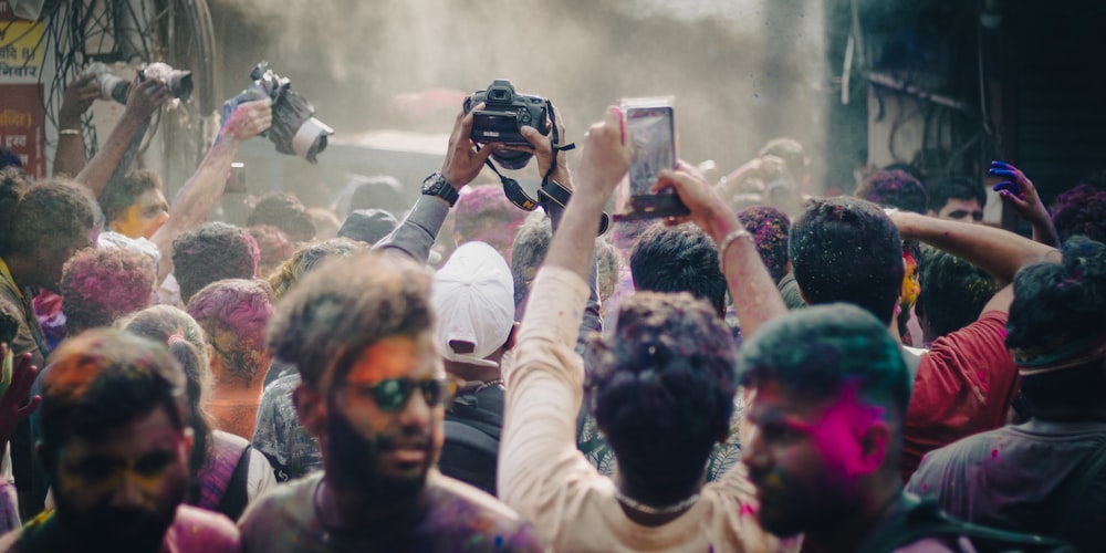 a crowd of people covered in colored powder