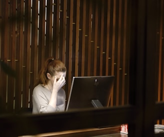 a woman sitting in front of a laptop computer