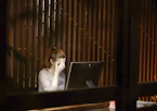 a woman sitting in front of a laptop computer