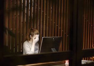 a woman sitting in front of a laptop computer