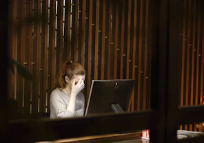 a woman sitting in front of a laptop computer