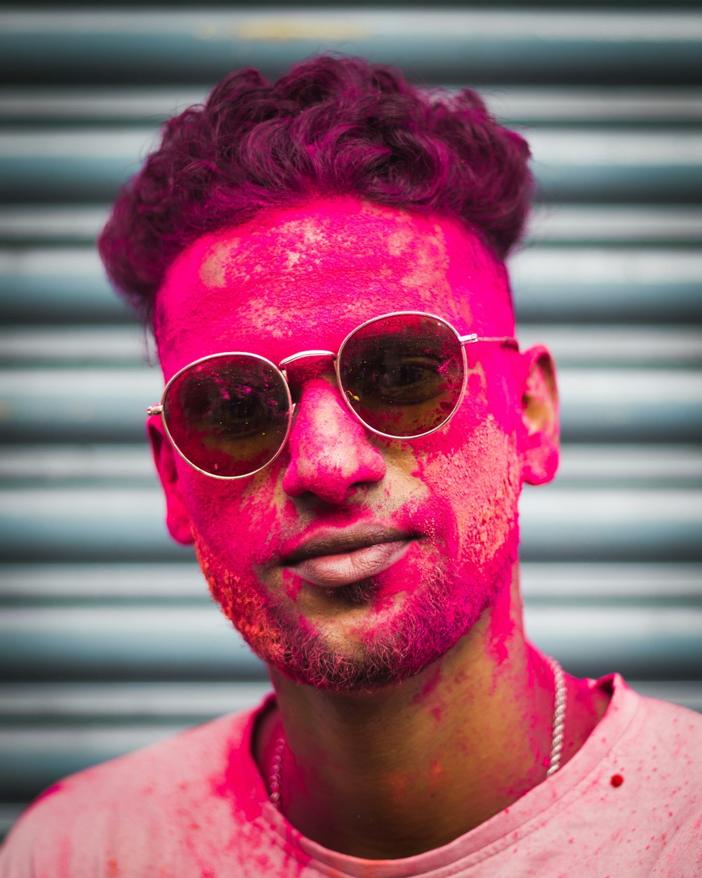 a man wearing sunglasses and a pink shirt