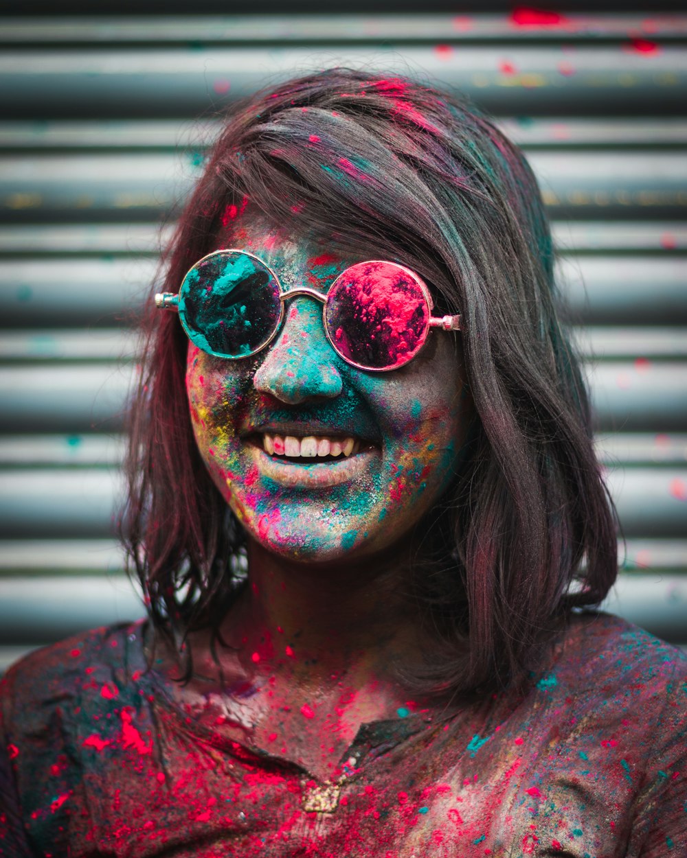 a woman with painted face and sunglasses posing for a photo