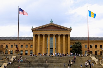 a group of people walking up and down steps in front of a building