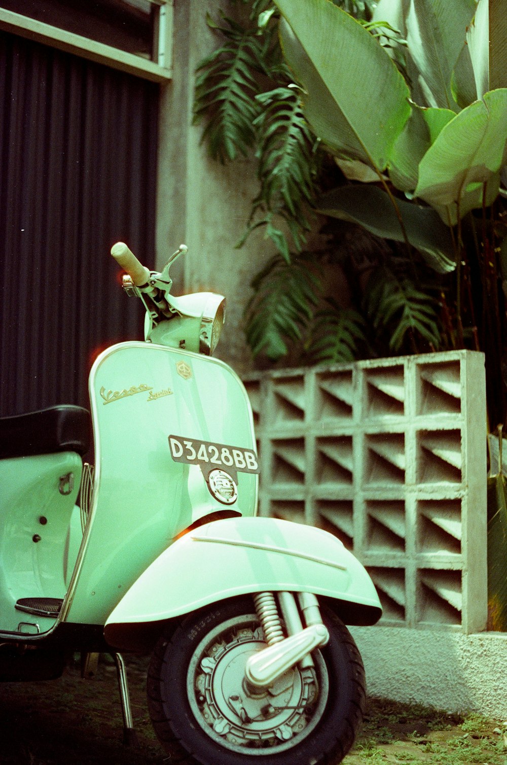 a green scooter parked in front of a building