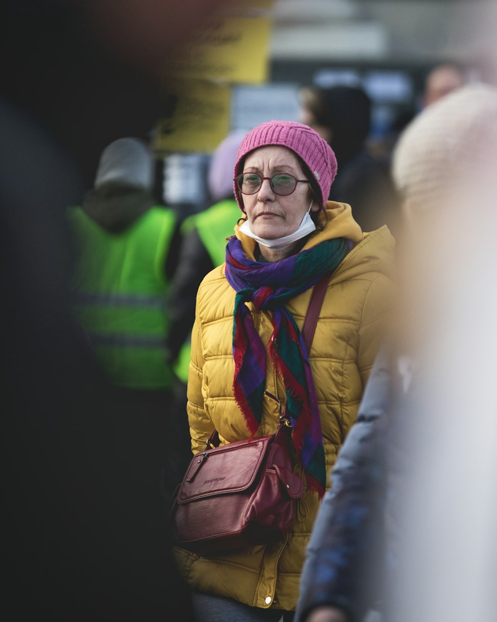 a woman wearing a yellow jacket and a pink hat