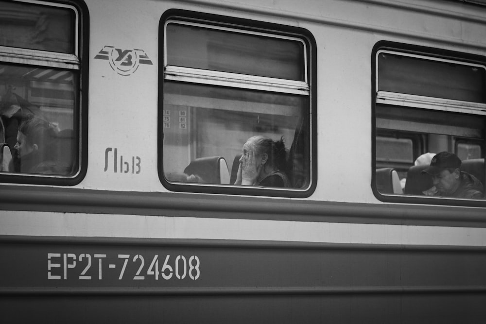 a black and white photo of people sitting in a train