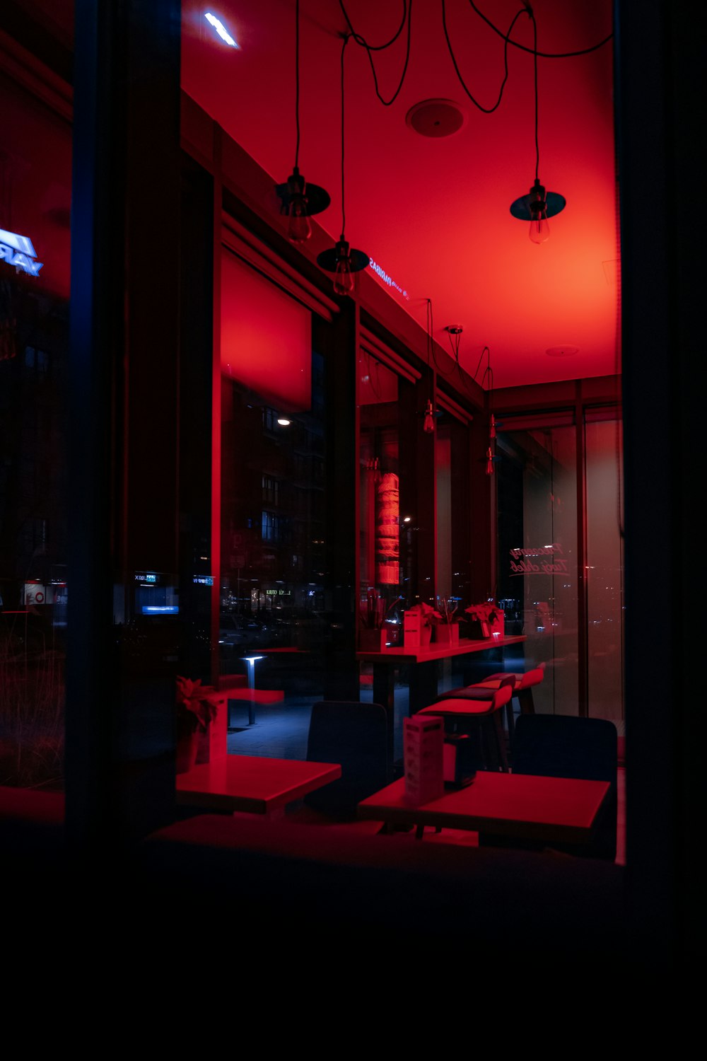 a dark room with red lighting and tables