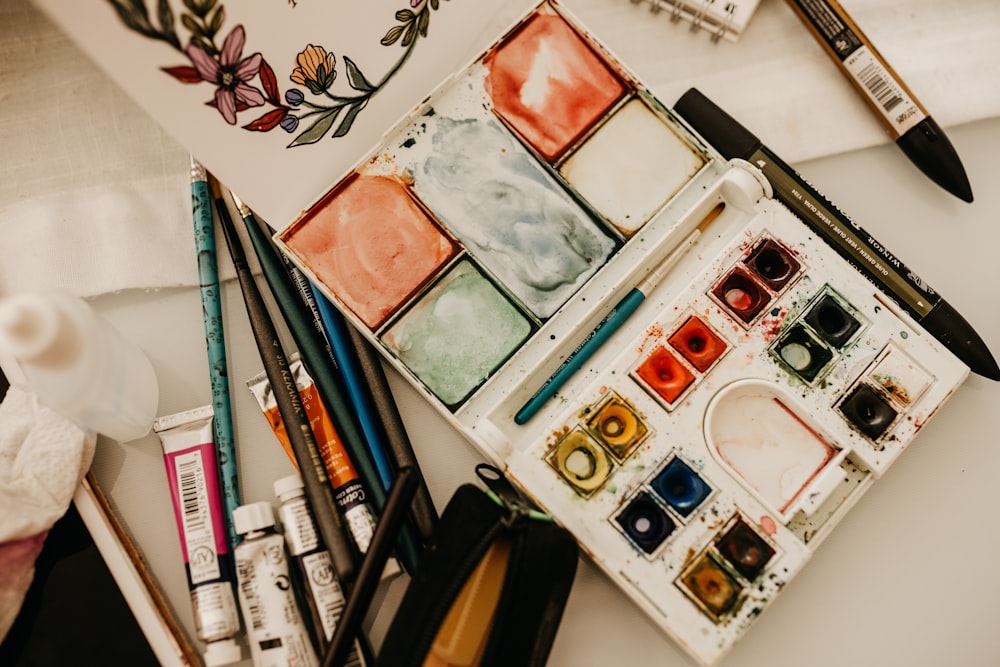 a close up of a table with paints and brushes