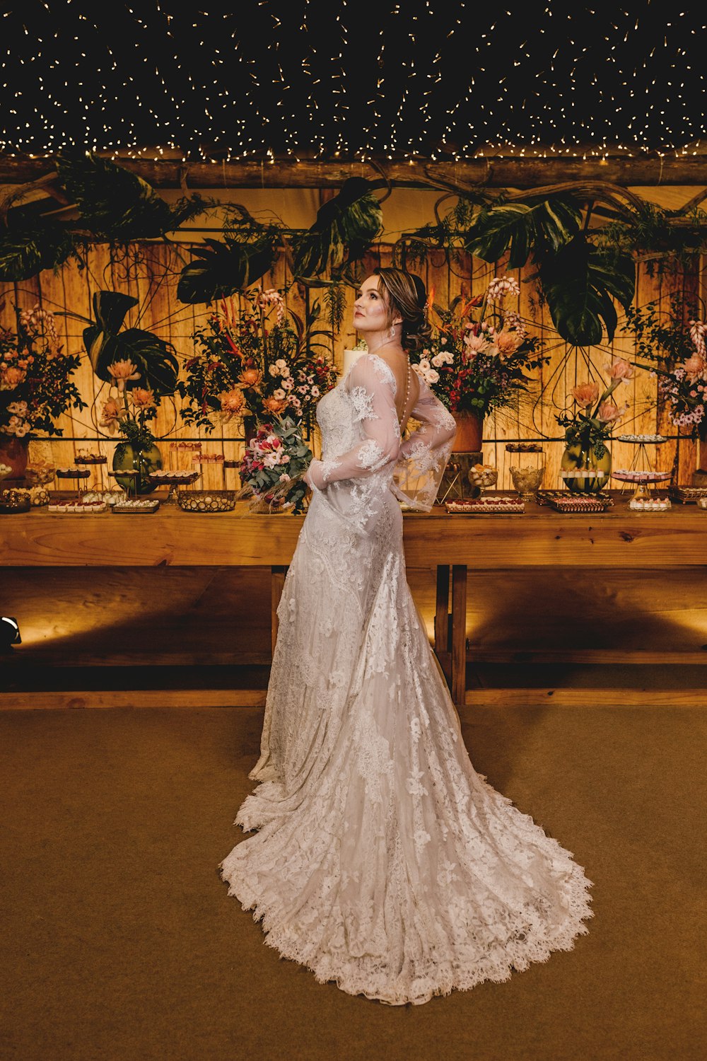 a woman in a wedding dress standing in front of a floral wall