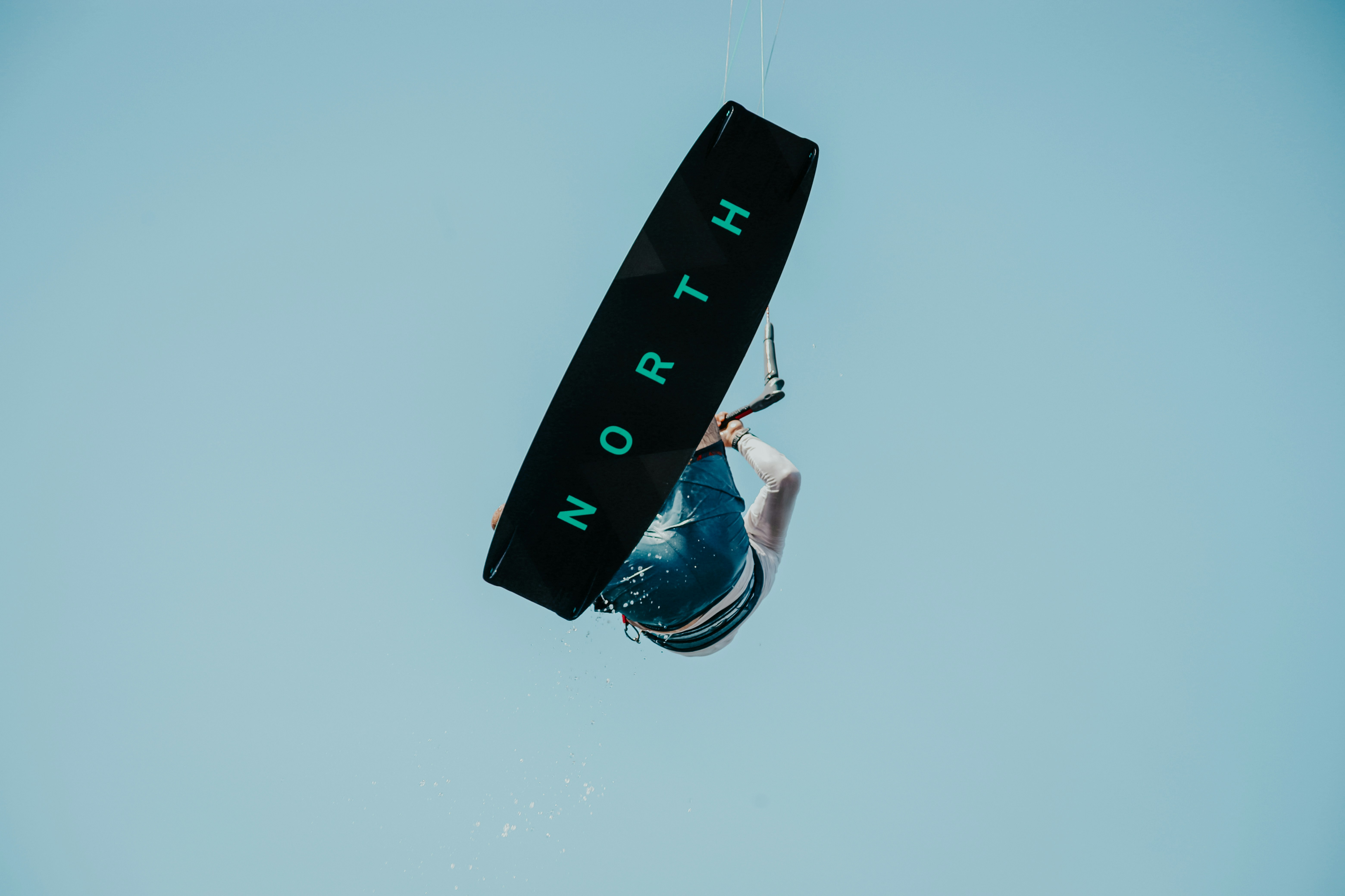 Foto Una persona en una tabla de surf en el aire Imagen Playa gratis