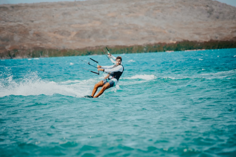 a man riding a kiteboard on top of a body of water