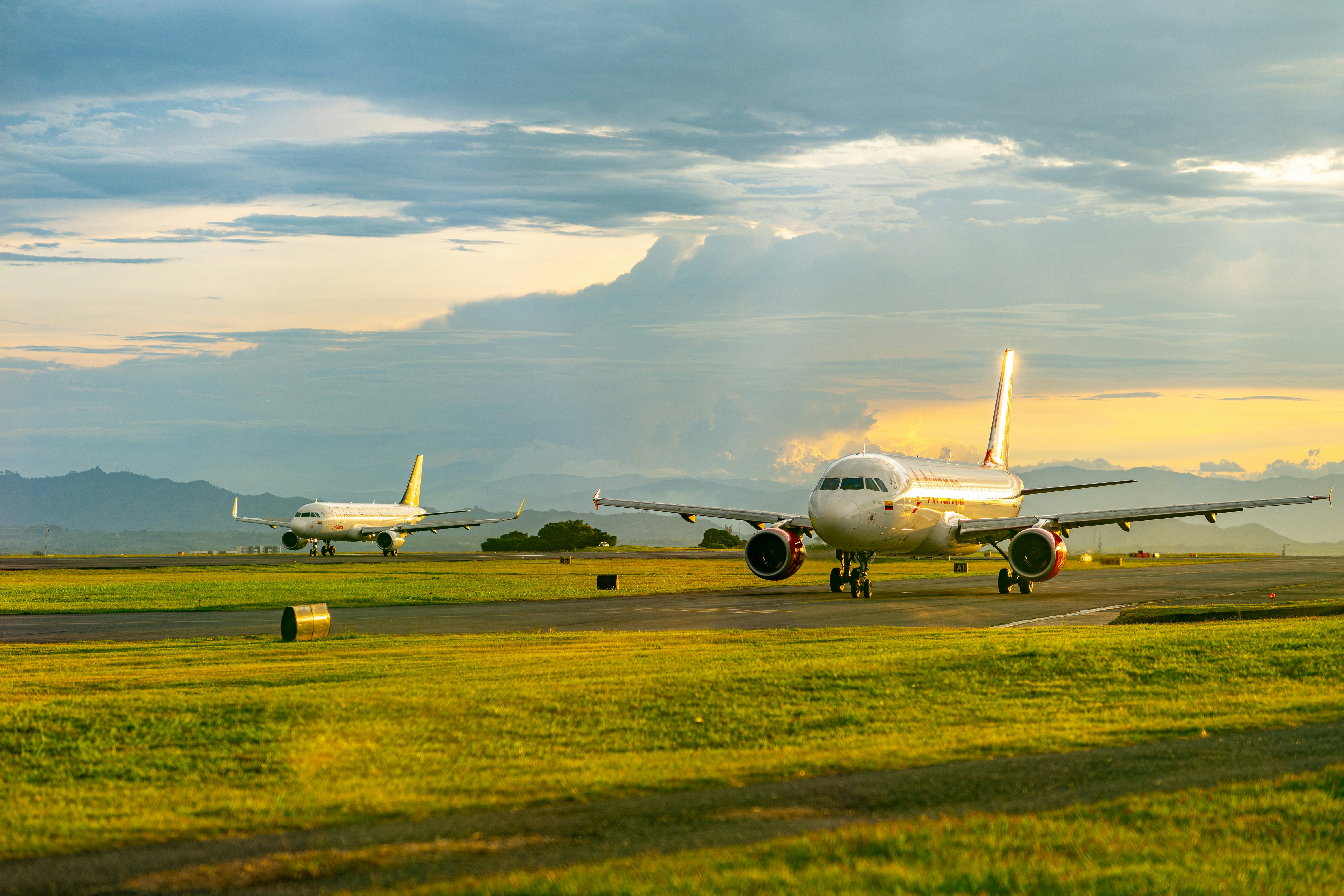 two airplanes on a runway with a cloudy sky, 