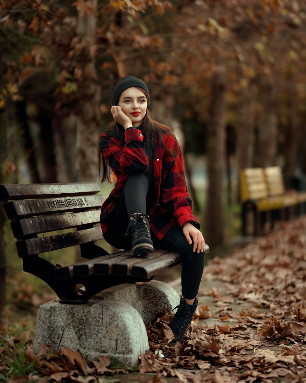 a woman sitting on a bench in a park