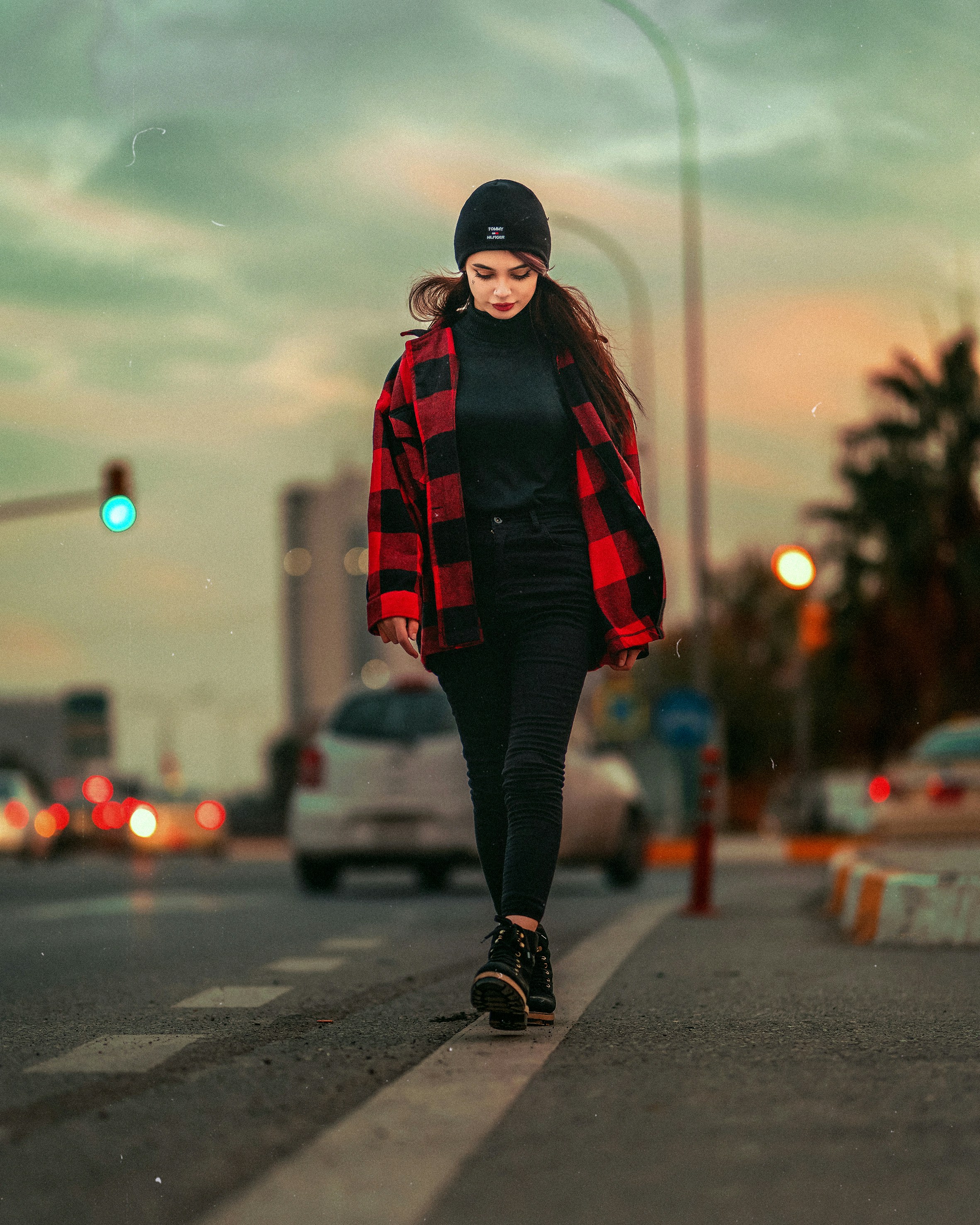 A woman walking down the street in a red and black jacket photo – Free ...