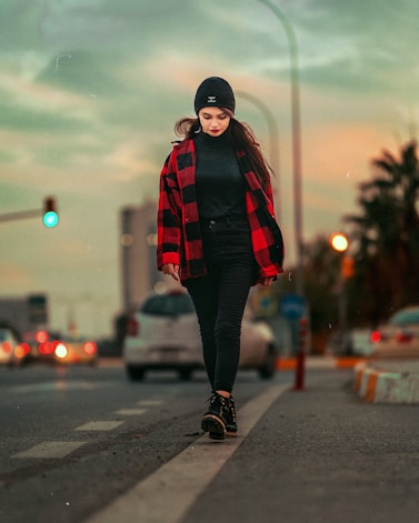 a Kurdish woman walking down the street in a red and black jacket