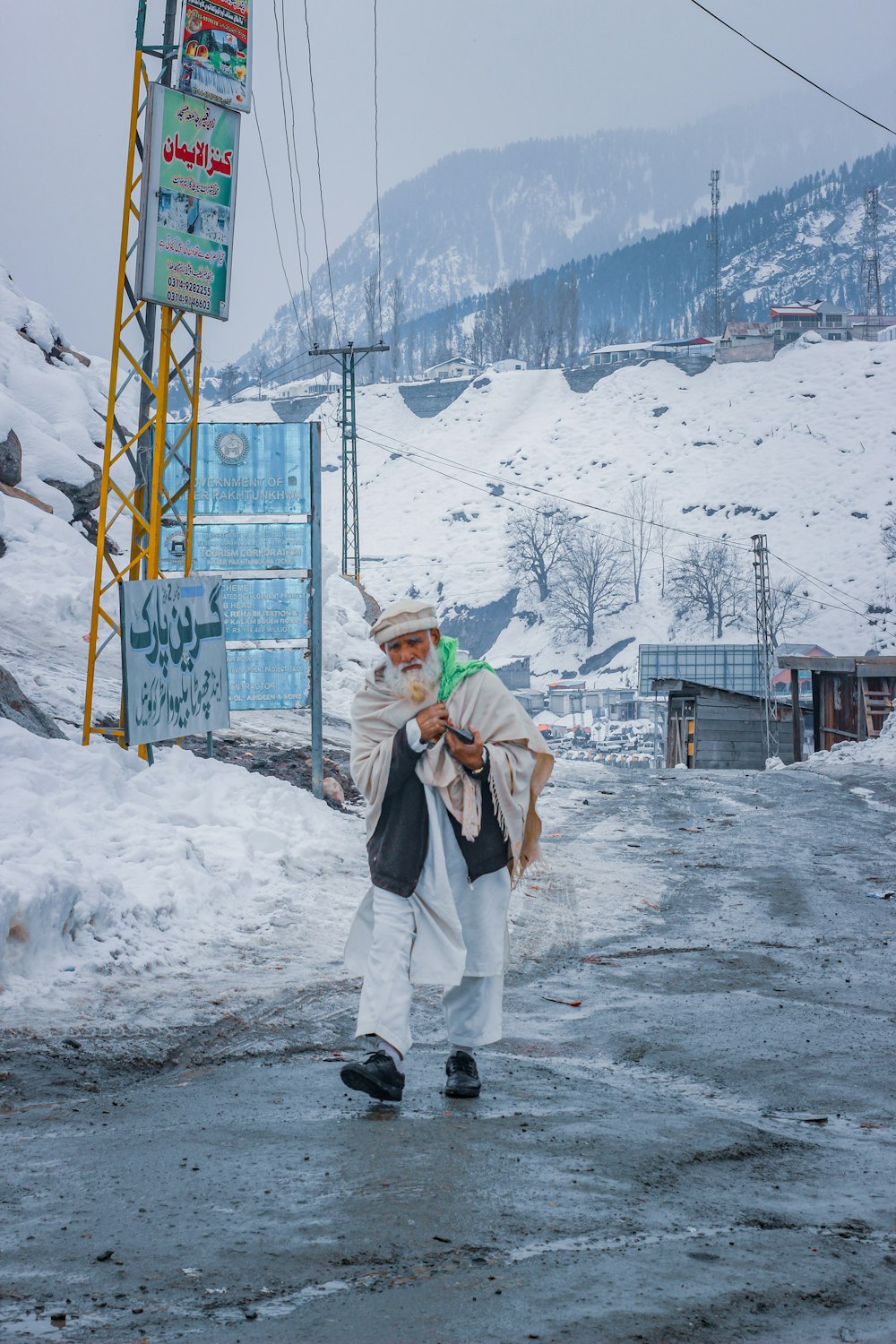 a man walking down a snow covered road