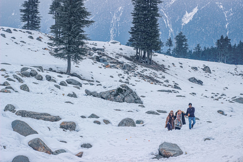 a group of people walking up a snow covered hill