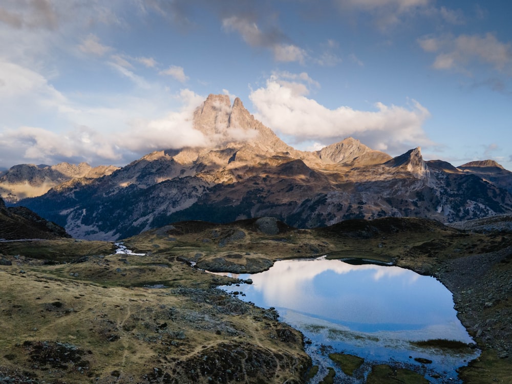 uma cordilheira com um lago em primeiro plano