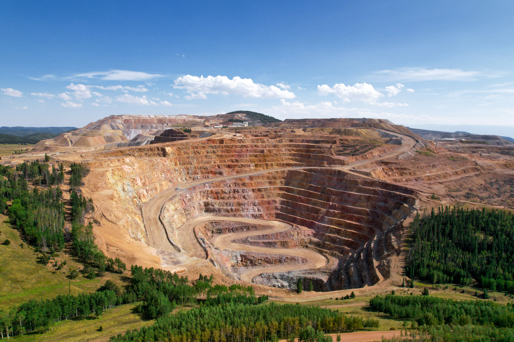 Open-pit lithium mine surrounded by forest