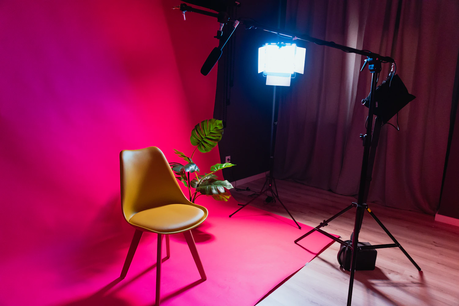 A chair standing on a magenta studio set under a single light