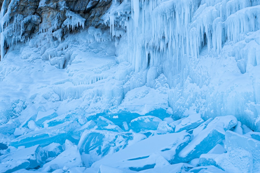 a man standing in front of a frozen waterfall