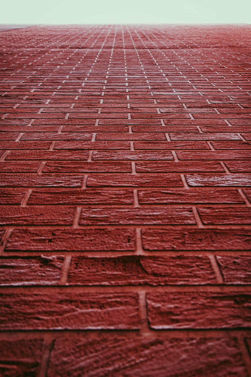 a red brick wall with a white sky in the background