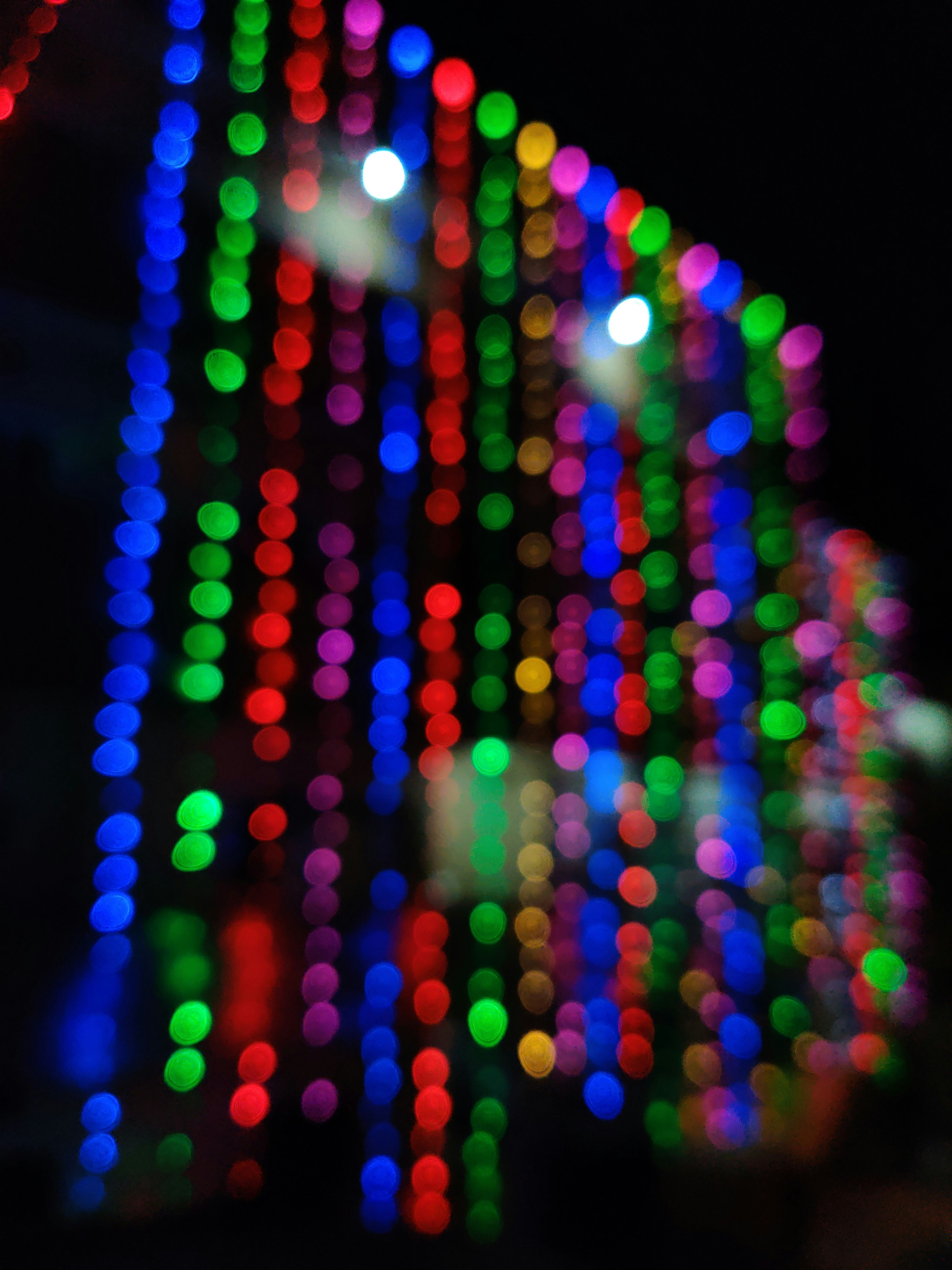 A blurry photo of a building with a lot of lights on it photo ...