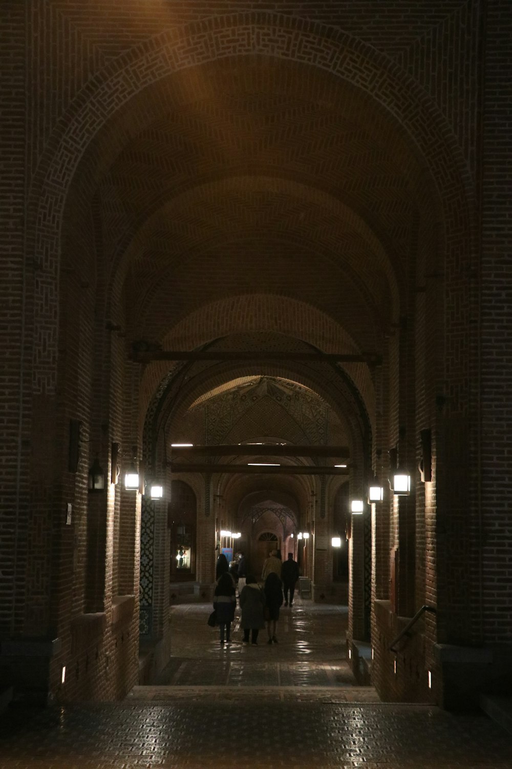 a group of people walking down a long hallway