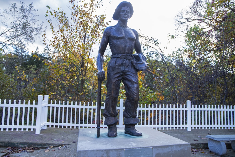 a statue of a woman with a hat and a cane