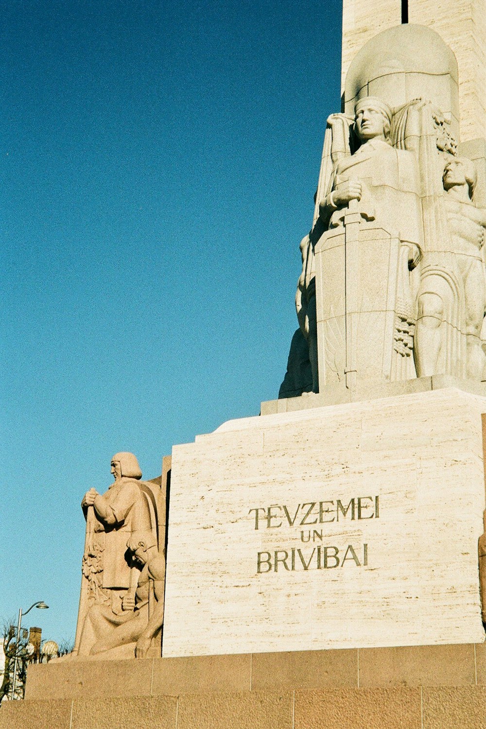 a statue of a man holding a cross in front of a building