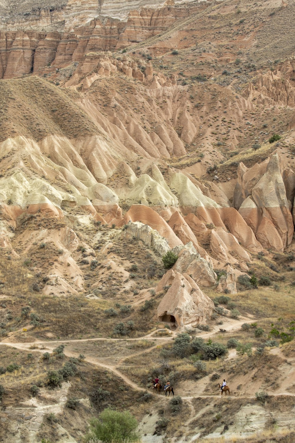 a group of people riding horses down a dirt road