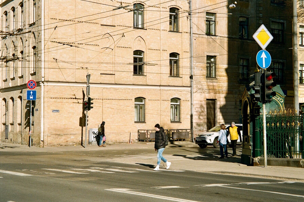 a group of people crossing a street in front of a building
