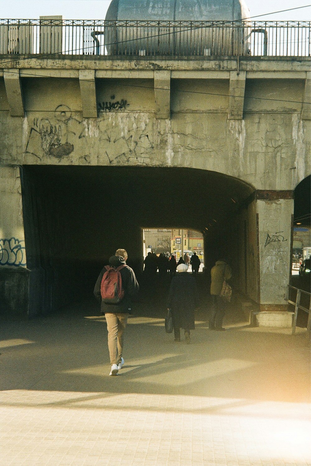 a group of people walking under a bridge