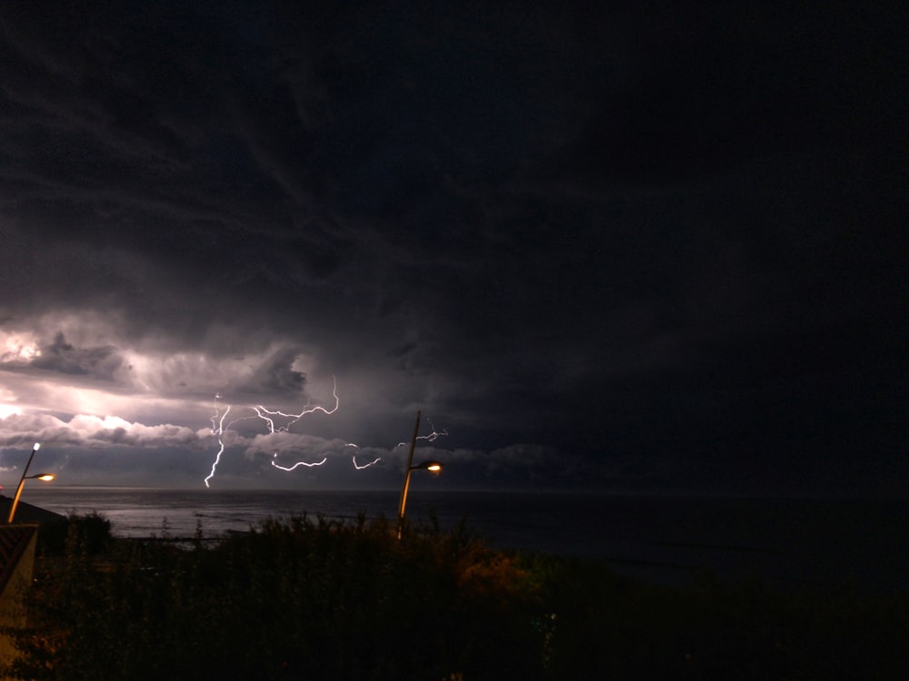 a lightning storm is seen over the ocean