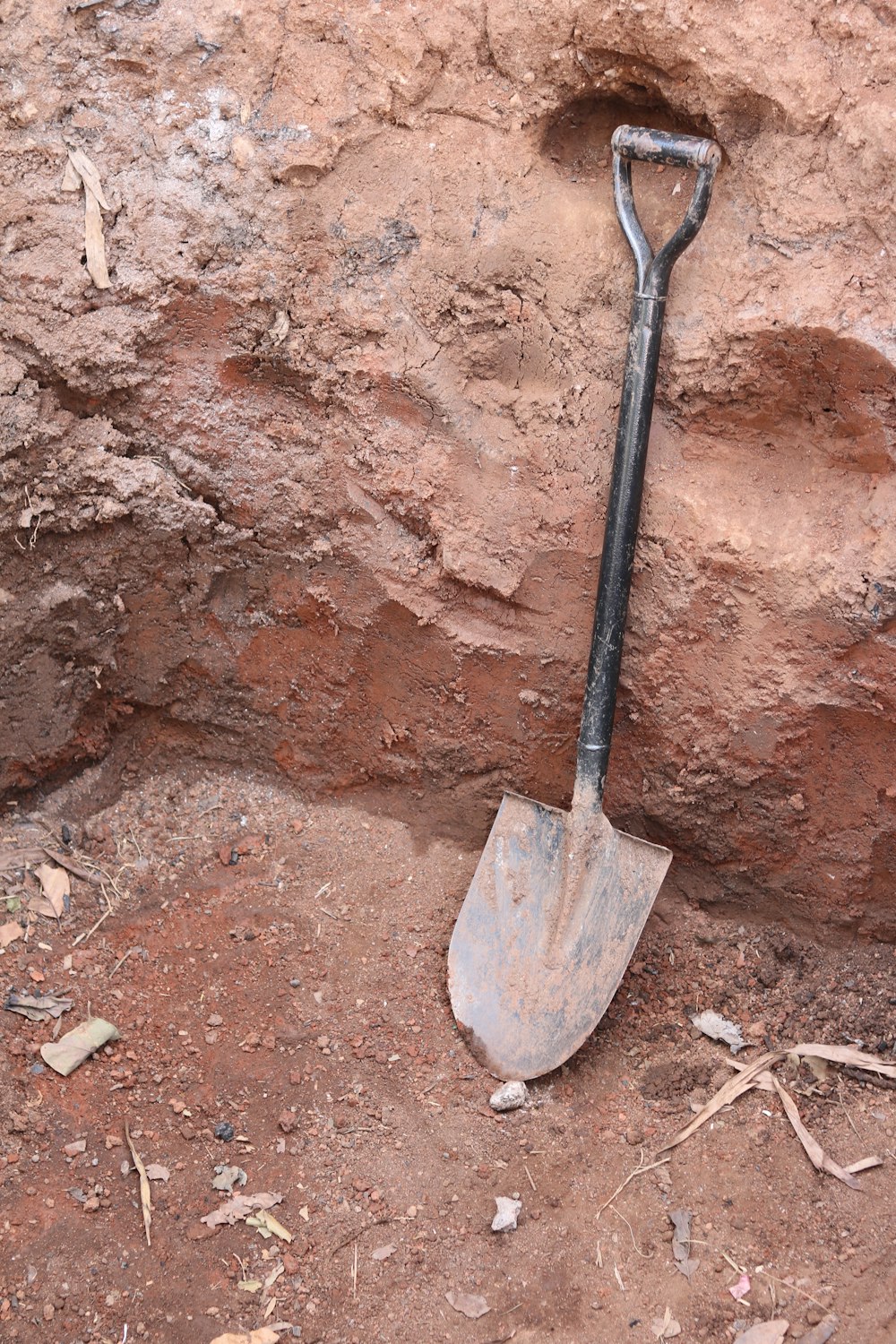 a shovel stuck in the ground next to a rock