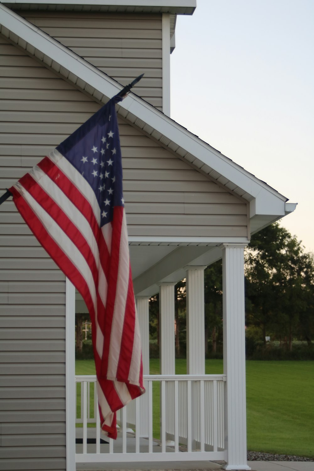 an american flag hanging from the side of a house