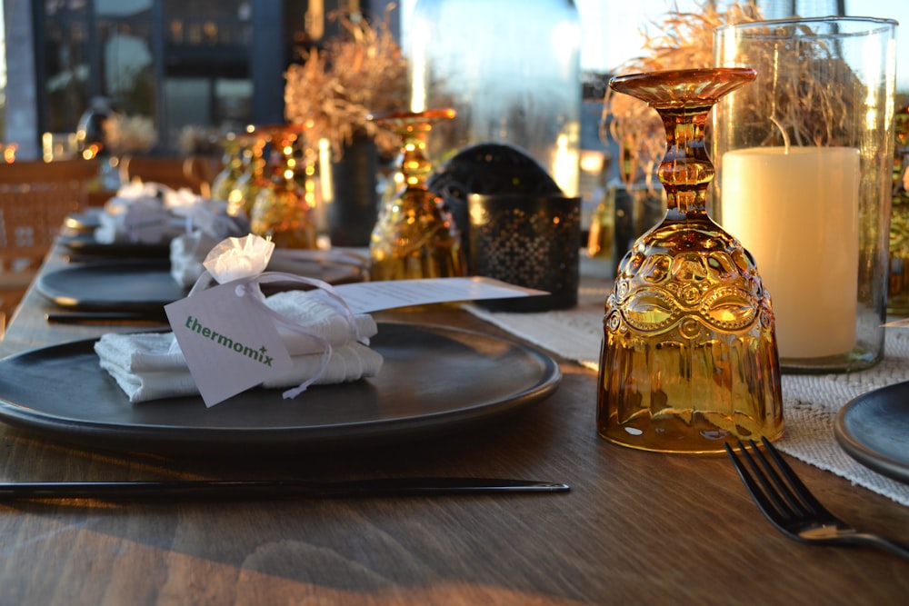 a table set for a formal dinner with candles and napkins